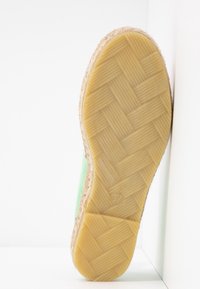 Chaussure espadrille verte avec une tige en jute texturé et une semelle en caoutchouc avec un motif tissé. La couleur de la semelle est beige clair. La taille indiquée est 37.