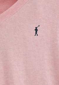 Lichtroze gebreide trui met een V-hals, voorzien van een donkerblauw geborduurd logo van een figuur die een stok vasthoudt op de linkerborst.