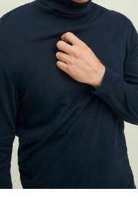 Maglione a collo alto blu navy in un tessuto morbido. Presenta una silhouette aderente con maniche lunghe e un colletto a costine.