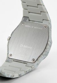 Correa de reloj de silicona con un patrón gris, con una tapa trasera de acero inoxidable, detalles grabados y un número de serie. Modelo: D1 Milano.
