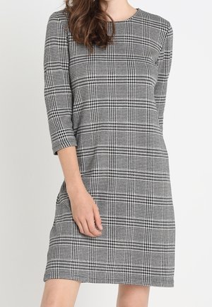 Mustat ja valkoiset ruudulliset mekko, jossa on kolmannen neljänneksen hihat, pyöreä pääntie ja suora leikkaus. Pehmeä, tekstuuri kangas ilman kiinnityksiä.