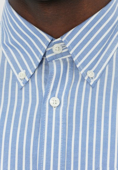 Camisa de botones de rayas azules con líneas blancas, presenta un cuello clásico y dos botones en la tapeta del cuello. Tejido de algodón fresco.