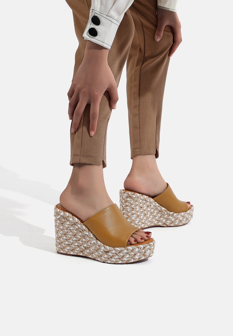 Sandali con tacco a cuneo in pelle marrone con una piattaforma in giuta intrecciata, caratterizzati da un design con punta aperta e una finitura liscia.