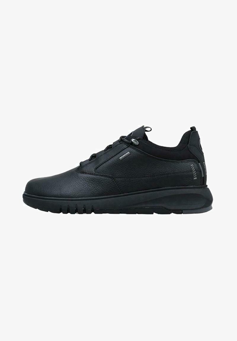 Black leather sneakers with a textured finish, rounded toe, and low profile. Features elastic laces and a cushioned black sole. Breathable panels.