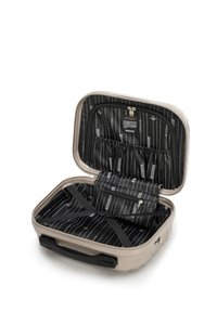 Valigia rigida beige con interni neri. Presenta diverse tasche, strap elastici per fissare gli oggetti e un compartimento con cerniera.