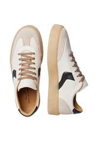 Sneaker bianche e beige con una parte superiore in suede e pelle. Presentano lacci marroni, un accento nero sul lato e una suola in gomma beige.