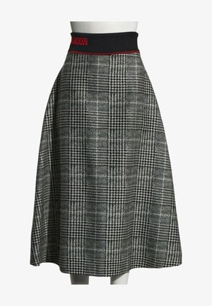 Jupe midi à taille haute à carreaux pied-de-poule noir et blanc avec une ceinture élastique noire ornée d'un détail en chiffres romains rouges.