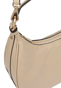 Beige leren schoudertas met een textuur, goudkleurige hardware, ritssluiting en een zwarte accent langs de rand.