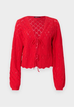 Rød strikket cardigan med V-hals, lange ermer og blondermønstrete tekstur. Har en knyttefront og design med bølgete kant.