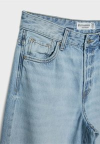 Vaaleansiniset farkut korkeavyötäröisellä mallilla, joissa on etu- ja takataskut, kontrastitikkaukset sekä vetoketju- ja nappisuljenta.