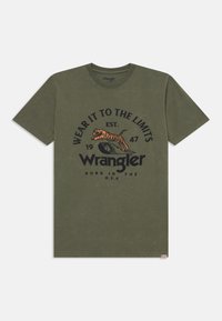 T-shirt in cotone verde oliva con stampa grafica di una tigre e testo in nero. Maniche corte, design a girocollo e un piccolo etichetta all'orlo.