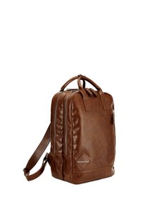 Mochila de cuero marrón con doble cremallera, asas superiores y una correa de hombro detachable. Presenta un acabado texturizado y un acento sutil con el logo.