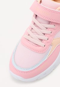 Sapatilha rosa clara com material em malha e sintético, apresentando uma tira de Velcro, atacadores texturizados e detalhes em azul claro contrastantes. Logo da Kappa presente.
