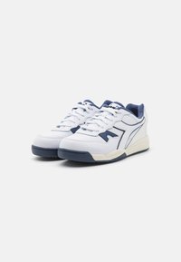 Sneakers bianchi con dettagli in blu navy, caratterizzati da materiali in pelle e rete, texture perforata, punta tonda, chiusura con lacci e suola in gomma.