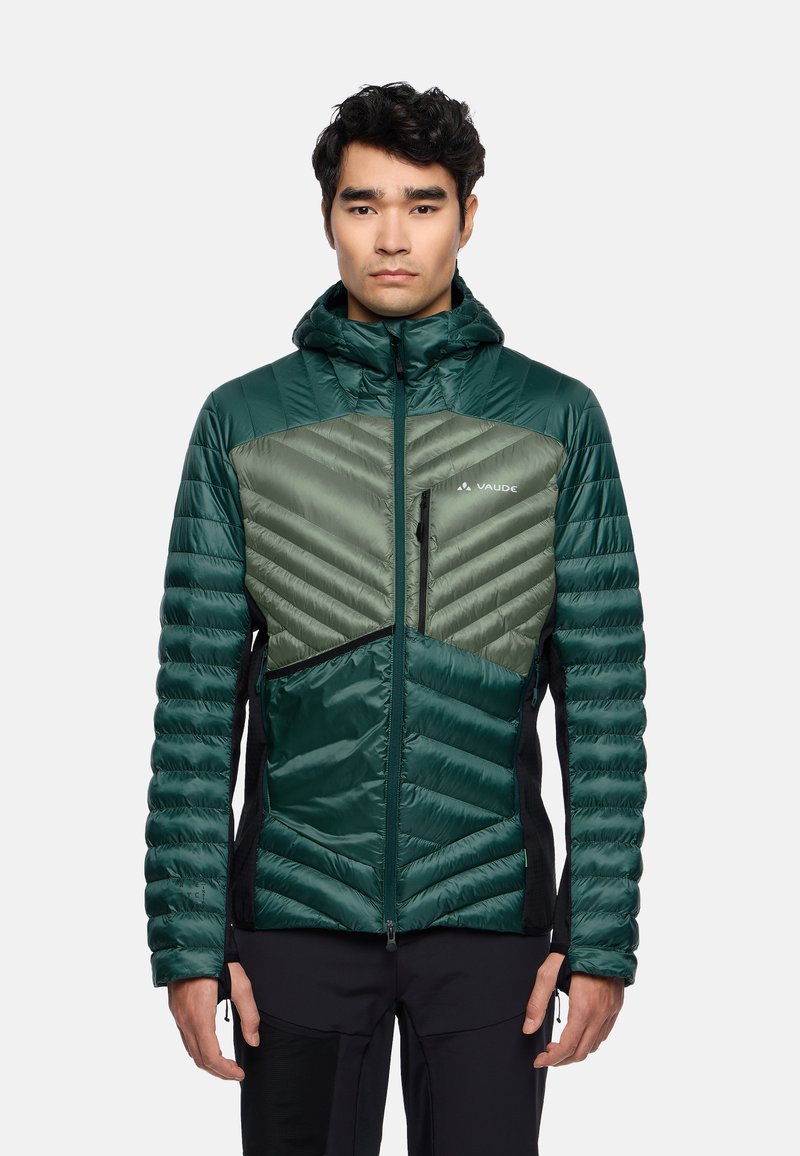 Grüne isolierte Jacke mit Kapuze, die ein Chevron-Design, kontrastierende Texturen und Reißverschluss-Taschen aufweist, entworfen für den Outdoor-Einsatz.