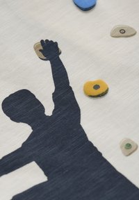 Baumwollstoff mit einer marineblauen Silhouette eines Kletterers, der nach bunten Griffen greift. Der Hintergrund ist in einem hellen, strukturierten Cremefarbton.