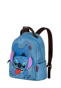 Mochila de lona azul con un diseño bordado de un personaje de dibujos animados con orejas rosas y una expresión juguetona. Incluye un bolsillo frontal y correas marrones.