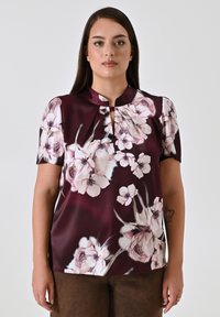 Blusa a maniche corte in satin bordeaux scuro con un motivo floreale in rosa chiaro e crema, dotata di scollatura a chiave e colletto arrotondato.
