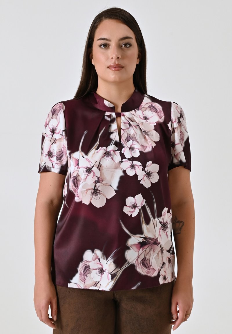 Blusa a maniche corte in satin bordeaux scuro con un motivo floreale in rosa chiaro e crema, dotata di scollatura a chiave e colletto arrotondato.
