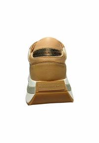 Beige Leder-Sneaker mit einem strukturierten goldenen Akzent an der Ferse, ausgestattet mit einer dicken weißen und beigen Sohle, die mit „ALEXANDER SMITH“ geprägt ist.