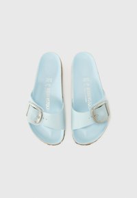 Ljusblå Birkenstock-sandaler med en enda rem och metallspänne. Slät ovandel och mjuk fotbädd, platt korksula. Storlek 37.