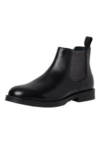 Botín Chelsea de cuero negro con paneles elásticos en los laterales, punta redondeada y un tacón bajo apilado. Cuenta con una lengüeta para facilitar el uso.