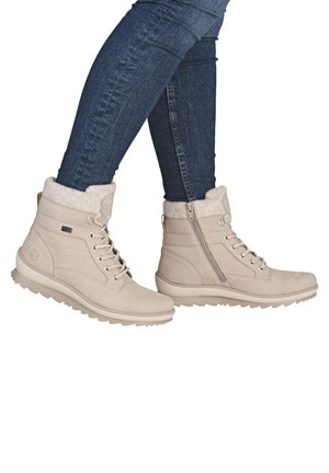 Beige ankle boots with faux fur lining, lace-up front, and side zipper; made from suede-like material with a rugged rubber sole.