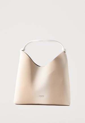 Beige DKNY håndtaske med en buet topkant og et enkelt hvidt håndtag mod en ensfarvet lys baggrund.