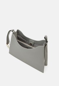 Szara skórzana torba na ramię o gładkiej fakturze, z zaokrąglonym górnym brzegiem i wewnętrzną kieszenią. Posiada odpinany pasek i złote akcenty.