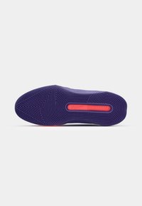 Nike sneaker outsole in purple rubber with a textured zigzag pattern, featuring a prominent orange Nike logo detail.
