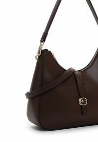 Brown leather handbag with a curved shape, a gold hardware accent, and a detachable shoulder strap. Features a zipper along the top.