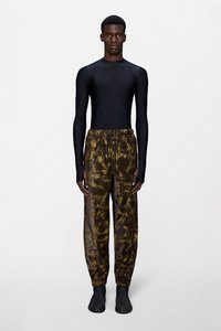 Μαύρο μακρυμάνικο τοπ συνδυασμένο με καφέ τζόγερς με σχέδιο tie-dye. Οι τζόγερς έχουν ελαστική μέση και ρεβέρ στα τελειώματα. Μαύρα παπούτσια συμπληρώνουν το σύνολο.