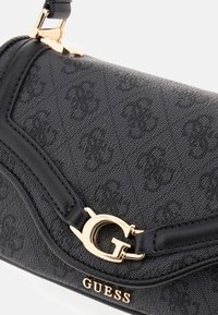 Borsa nera dal design strutturato realizzata in materiale sintetico, con una chiusura in tono oro, un accento del logo e un design elegante con bordi curvi.