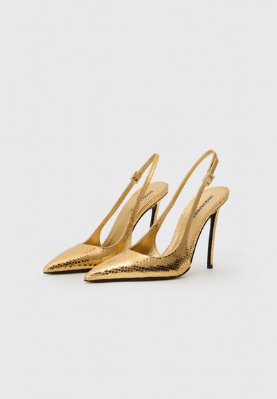 Tacones slingback de charol dorado con punta afilada, estampado de serpiente texturizado, tacón de aguja de 10 cm y correa de tobillo ajustable.