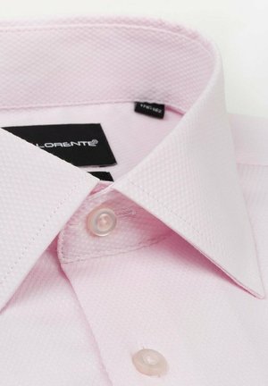 Jasnoróżowa koszula z tkaniny o fakturze, z ostrym kołnierzykiem i przezroczystymi guzikami. Wewnątrz kołnierzyka widoczna metka z nazwą marki.