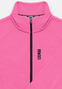 Mīkstais rozā vilnas jaka ar rāvējslēdzēju, ar augstu apkakli un priekšējo rāvējslēdzēju. Melnais "COLMAR" logo sānos kā detalizācija. Gluda tekstūra.