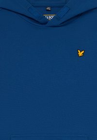 Sudadera azul con un logo de pájaro bordado amarillo en el lado derecho del pecho y un bolsillo tipo canguro en la parte frontal.