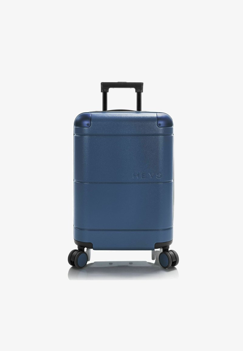 Dunkelblauer Hartschalenkoffer mit strukturierter Oberfläche, ausziehbarem schwarzen Griff, vier kleinen Rädern und eingeprägtem Markenlogo auf der Vorderseite.