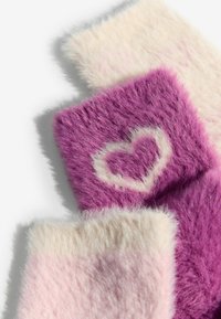 Mākslīgā kažokāda dažādos rozā un violetos toņos. Ievērojama sirds raksts krēmkrāsā uz purpura fona. Mīksta, teksturēta virsma.