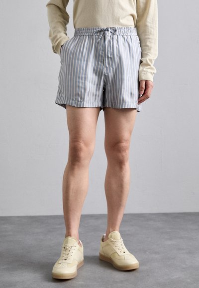Pantaloncini a righe blu chiaro e bianchi con vita elastica e cordino. Due tasche laterali; tessuto leggero, vestibilità comoda.