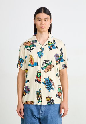 Korte mouw shirt gemaakt van lichtgewicht stof, met een crème achtergrond en kleurrijke tatoeage-geïnspireerde patronen en knopen aan de voorkant.