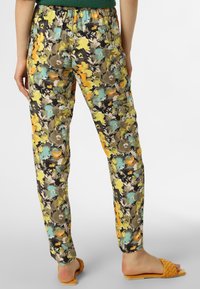 Spodnie w kwiatowy wzór z mieszanką zielonych, żółtych, pomarańczowych i czarnych kolorów; elastyczna talia; zwężany krój; lekka tkanina.