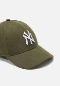 Olíva zöld baseball sapka texturált anyagból, fehér hímzett "NY" logóval az elején és ívelt napszemüveggel.