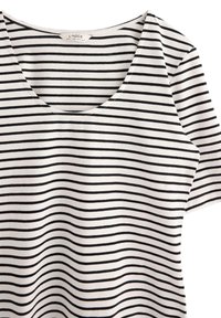 Sort-hvid stribet T-shirt med rund hals og korte ærmer. Fremstillet af blødt bomuldsstof med et jævnt stribemønster.