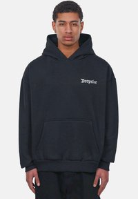 Sort oversized hættetrøje lavet af blødt materiale. Har en kængurulomme og hvid "Dropsize" tekst på venstre side. Ribbet afslutning ved håndled og nederste kant.