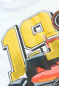 White cotton t-shirt featuring a large yellow "19" graphic, with a racing car design in red and black, detailed with outlines and accents.