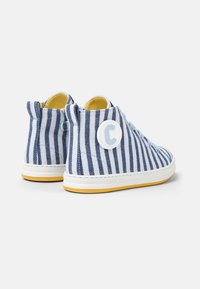 Scarpe alte con una tomaia in tela a righe blu e bianche, fodera interna gialla, suola in gomma bianca e un logo circolare prominente sul tallone.