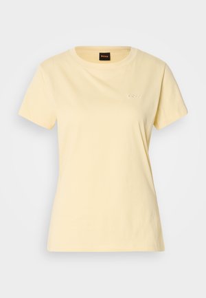 Gul kortermet t-skjorte laget av bomull med rund hals, med en liten brodert logo på brystet. Glatt tekstur, standard passform.
