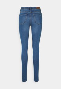 Jeans ajustados azul con cintura alta, que presentan un diseño clásico de cinco bolsillos y una textura suave de denim. Los bolsillos traseros están cosidos en forma de V.