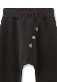 Schwarze Hose mit einem elastischen Bund und einem asymmetrischen Frontschlitz, der auf der rechten Seite von drei vertikalen Holzknöpfen gesichert wird.